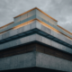 Klar abgegrenzte horizontale Schichten in moderner Architektur — visualisiert die Rangordnung der Private-Debt-Strukturen von Senior bis PIK.