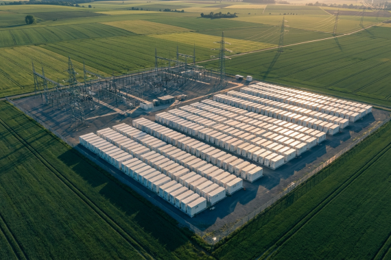 BESS-Markt Deutschland: Großspeicher-Anlage mit Batteriecontainern neben einem Umspannwerk in der deutschen Landschaft